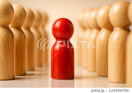 Red Peg, glossy red peg facing mirrored rows of light wood pegs creating contrast and separation under even bright light 129509700