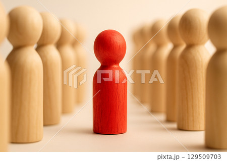 Focus on red wooden doll surrounded by other wooden dolls. Focus concept. 129509703