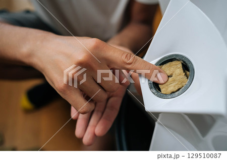 Close-up of farmer hand inserting rockwool cube into hydroponic tower, supporting seedling growth through precision soilless cultivation method. Concept of healthy and sustainable cultivation. 129510087
