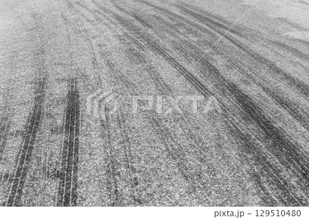 Black tire marks on road, Black rubber tire marks and tread marks, Tire trace track wheels texture and background, Auto tire tread grunge, Car wheel tyre tread track black tyre print, Aerial view. Black tire marks on road, Black rubber tire marks and tread marks, Tire trace track wheels texture and background, Auto tire tread grunge, Car wheel tyre tread track black tyre print, Aerial view. 129510480