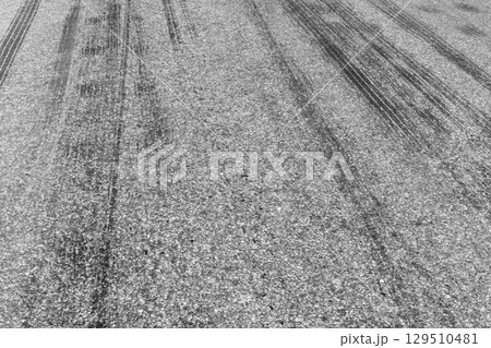 Black tire marks on road, Black rubber tire marks and tread marks, Tire trace track wheels texture and background, Auto tire tread grunge, Car wheel tyre tread track black tyre print, Aerial view. Black tire marks on road, Black rubber tire marks and tread marks, Tire trace track wheels texture and background, Auto tire tread grunge, Car wheel tyre tread track black tyre print, Aerial view. 129510481