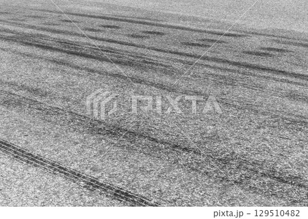 Black tire marks on road, Black rubber tire marks and tread marks, Tire trace track wheels texture and background, Auto tire tread grunge, Car wheel tyre tread track black tyre print, Aerial view. 129510482