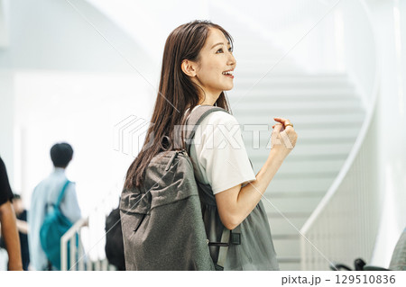 リュックを背負って一人で出かける女性 129510836