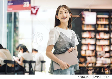 図書館で立つ笑顔の若い女性 129510842