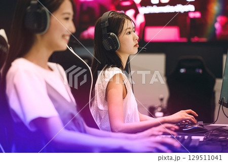 eスポーツの大会でゲームに参加する若い女性 129511041