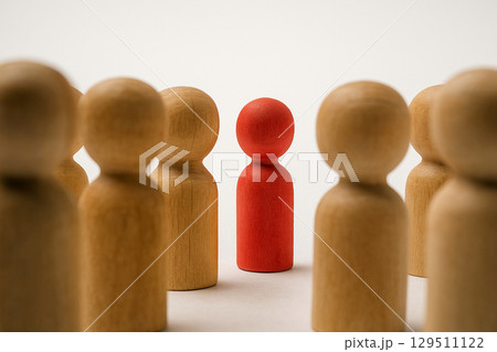 A red figurine closely surrounded by natural figurines symbolizing protection, attention, or scrutiny A red figurine closely surrounded by natural figurines symbolizing protection, attention, or scrutiny 129511122