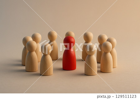 A group of natural figurines surrounding a red figurine symbolizing inclusion, support, or possible confrontation A group of natural figurines surrounding a red figurine symbolizing inclusion, support, or possible confrontation 129511123