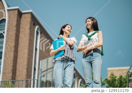 友達と大学内を歩く女子大生 129511170