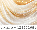 Innovative skin care cream texture creating a shimmering golden glow in a soft flowing pattern 129511681