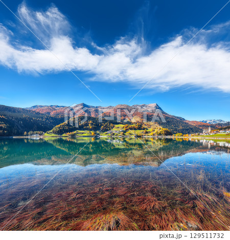 Picturesque autumn view of San Valentino village and Muta or Haidersee lake. 129511732