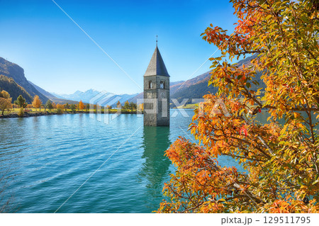 Astonishing autumn lake landscape with submerged bell tower in lake Resia or Reschensee. Astonishing autumn lake landscape with submerged bell tower in lake Resia or Reschensee. 129511795