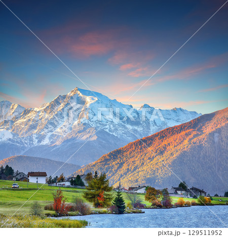 Gorgeous autumn view of Haidersee (Lago della Muta) lake with Ortler peak on background. 129511952