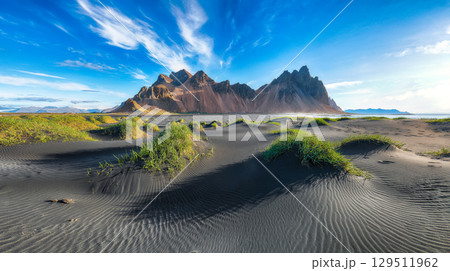 Amazing sunny day and gorgeous black sand dunes on Stokksnes cape in Iceland. 129511962