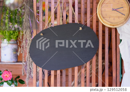 Decorative wooden board with a rustic clock and dried flowers in a cozy indoor setting. Copy space. Decorative wooden board with a rustic clock and dried flowers in a cozy indoor setting. Copy space. 129512058