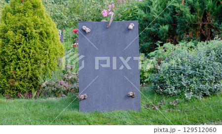 Slate sign with rope detail set against a garden backdrop. Copy space. Slate sign with rope detail set against a garden backdrop. Copy space. 129512060