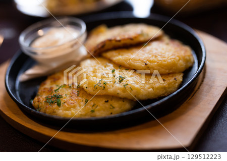 Potato pancakes with sour cream closeup. Belorussian cuisine 129512223