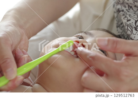 歯ブラシで赤ちゃんの口腔ケアする様子 129512763