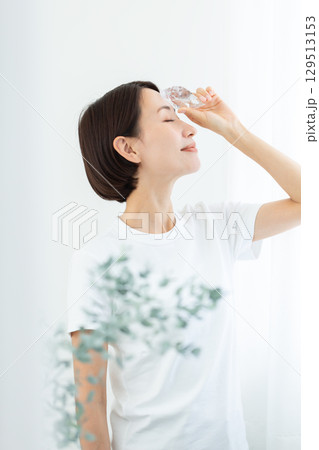 氷で肌を冷やす透明感のある女性 上半身 129513153