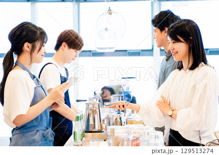 スマホで支払いをするカップル 129513274