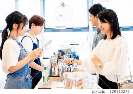 スマホで支払いをするカップル スマホで支払いをするカップル 129513275