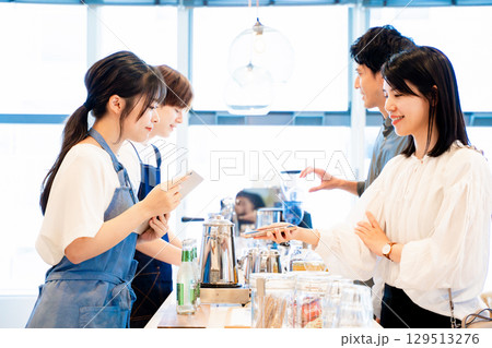 スマホで支払いをするカップル 129513276