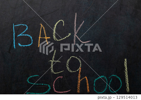 Colorful Chalk Letters Announce Back to School Season on a Chalkboard 129514013