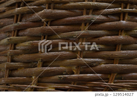 Intricate Weaving Texture Showcases the Artistry of a Handmade Basket in Warm Tones 129514027