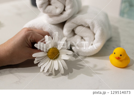 Enjoying a Moment of Relaxation With a Flower and Bath Accessories in a Serene Setting Enjoying a Moment of Relaxation With a Flower and Bath Accessories in a Serene Setting 129514073