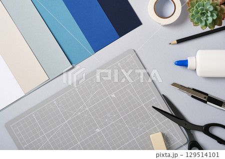 Paper craft materials and gray cutting mat with copyspace for your text. Handmade projects, design, and creativity. 129514101