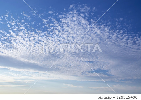 Cirrocumulus stratiformis clouds against blue sky. Beautiful sky with tiny clouds. Cirrocumulus stratiformis clouds against blue sky. Beautiful sky with tiny clouds. 129515400