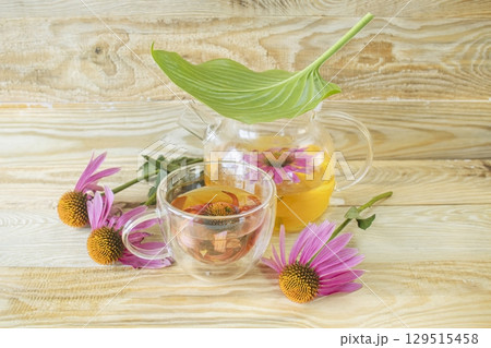 Echinacea flower tea in a glass teapot on a wooden background. Medicinal herbal tea from echinacea flowers. Echinacea flower tea in a glass teapot on a wooden background. Medicinal herbal tea from echinacea flowers. 129515458