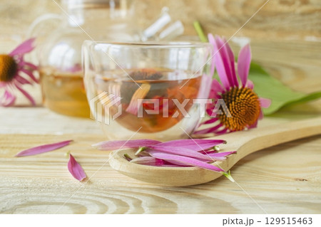 Echinacea flower tea in a glass teapot on a wooden background. Medicinal herbal tea from echinacea flowers. Echinacea flower tea in a glass teapot on a wooden background. Medicinal herbal tea from echinacea flowers. 129515463