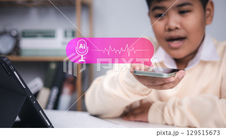 Speech recognition, voice command, and artificial intelligence technology. Young boy speaking to smartphone with AI voice assistant icon. Speech recognition, voice command, and artificial intelligence technology. Young boy speaking to smartphone with AI voice assistant icon. 129515673