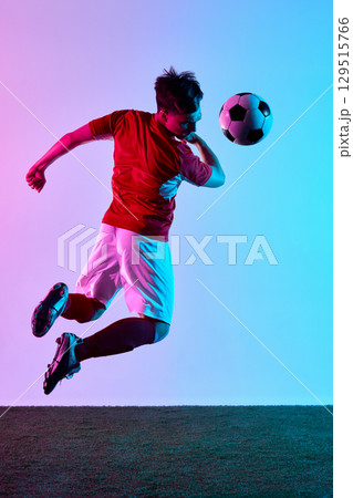Dynamic mid-air soccer header with focused determination 129515766