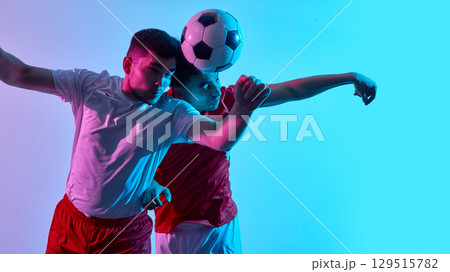 Intense soccer duel with dramatic lighting and focus Intense soccer duel with dramatic lighting and focus 129515782