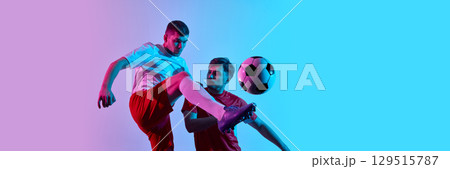 Soccer duel in colorful lighting with ball in air. Banner Soccer duel in colorful lighting with ball in air. Banner 129515787