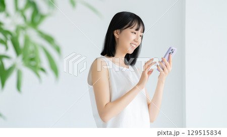 リビングでスマートフォンを使う女性 リビングでスマートフォンを使う女性 129515834