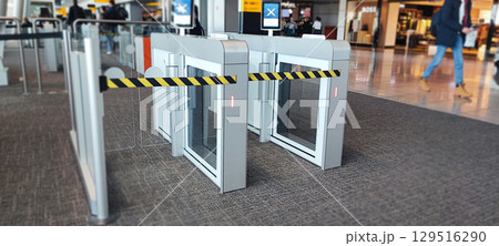 Modern airport security gate with yellow and black security barrier for passenger access control. Airport Security Gate Barrier concept 129516290