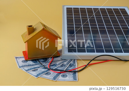 Composition with solar panel and model house on background. Composition with solar panel and model house on background. 129516730
