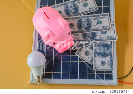 Composition with solar panel, led lamp, money and piggy bank on texture background. Composition with solar panel, led lamp, money and piggy bank on texture background. 129516734