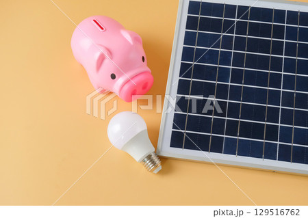 Composition with solar panel and piggy bank on background. Composition with solar panel and piggy bank on background. 129516762