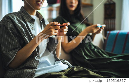 　二人でゲームを楽しむ休日の午後 129516827