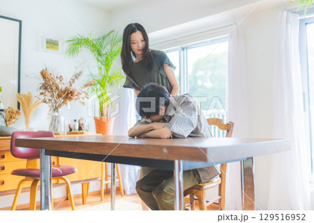 　テーブルで男性を見守る女性 129516952