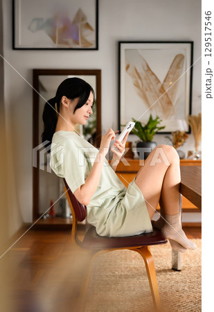 椅子に座ってスマホ操作を楽しむ女性 椅子に座ってスマホ操作を楽しむ女性 129517546