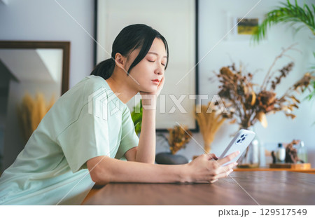 スマホで調べ物をする女性の真剣な表情 スマホで調べ物をする女性の真剣な表情 129517549