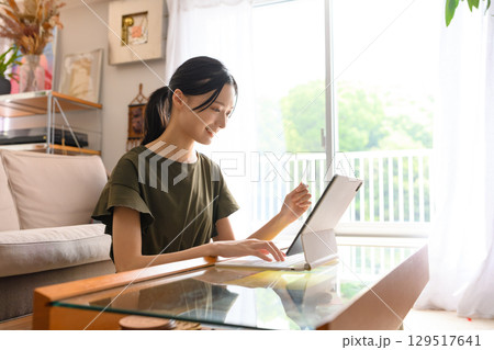自宅でタブレット操作する女性 自宅でタブレット操作する女性 129517641
