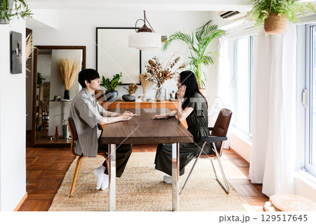 室内で向き合い談笑する男女 室内で向き合い談笑する男女 129517645
