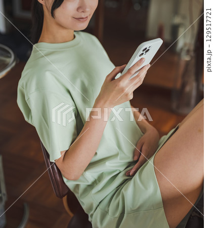 スマホを眺めるリラックスした女性のアップ スマホを眺めるリラックスした女性のアップ 129517721