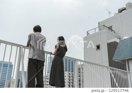 屋上で手すり越しに未来を考える男女 屋上で手すり越しに未来を考える男女 129517746