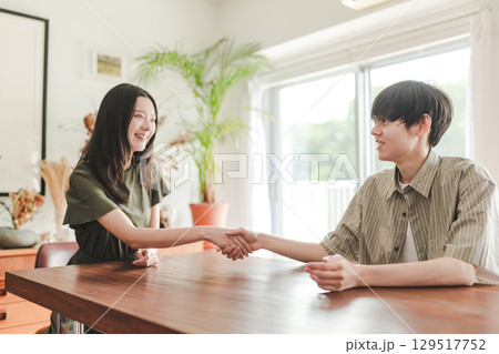 　握手を交わす男女の明るいシーン 129517752